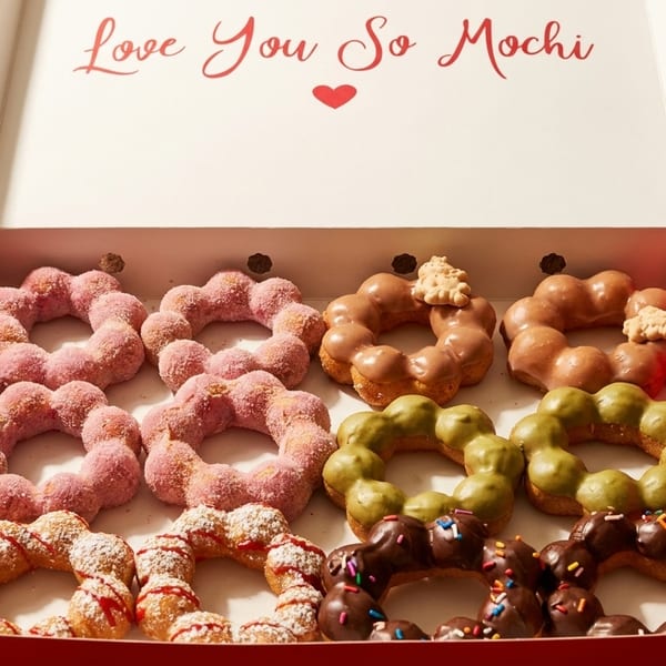 A red box of "Love You So Mochi" donuts in various flavors and toppings.