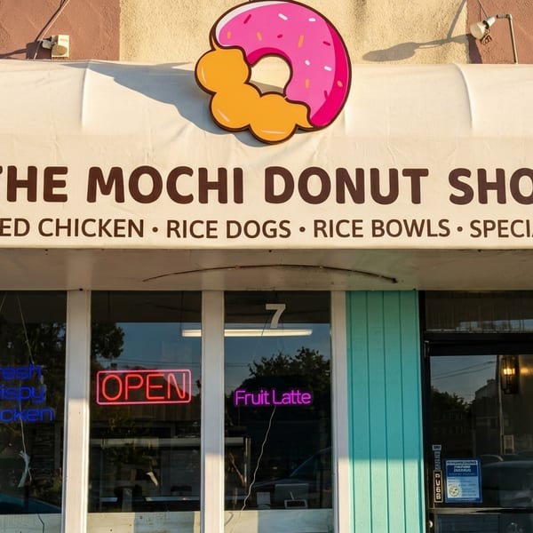 The Mochi Donut Shop storefront with a donut logo, advertising fried chicken, rice dogs, and specialty drinks.
